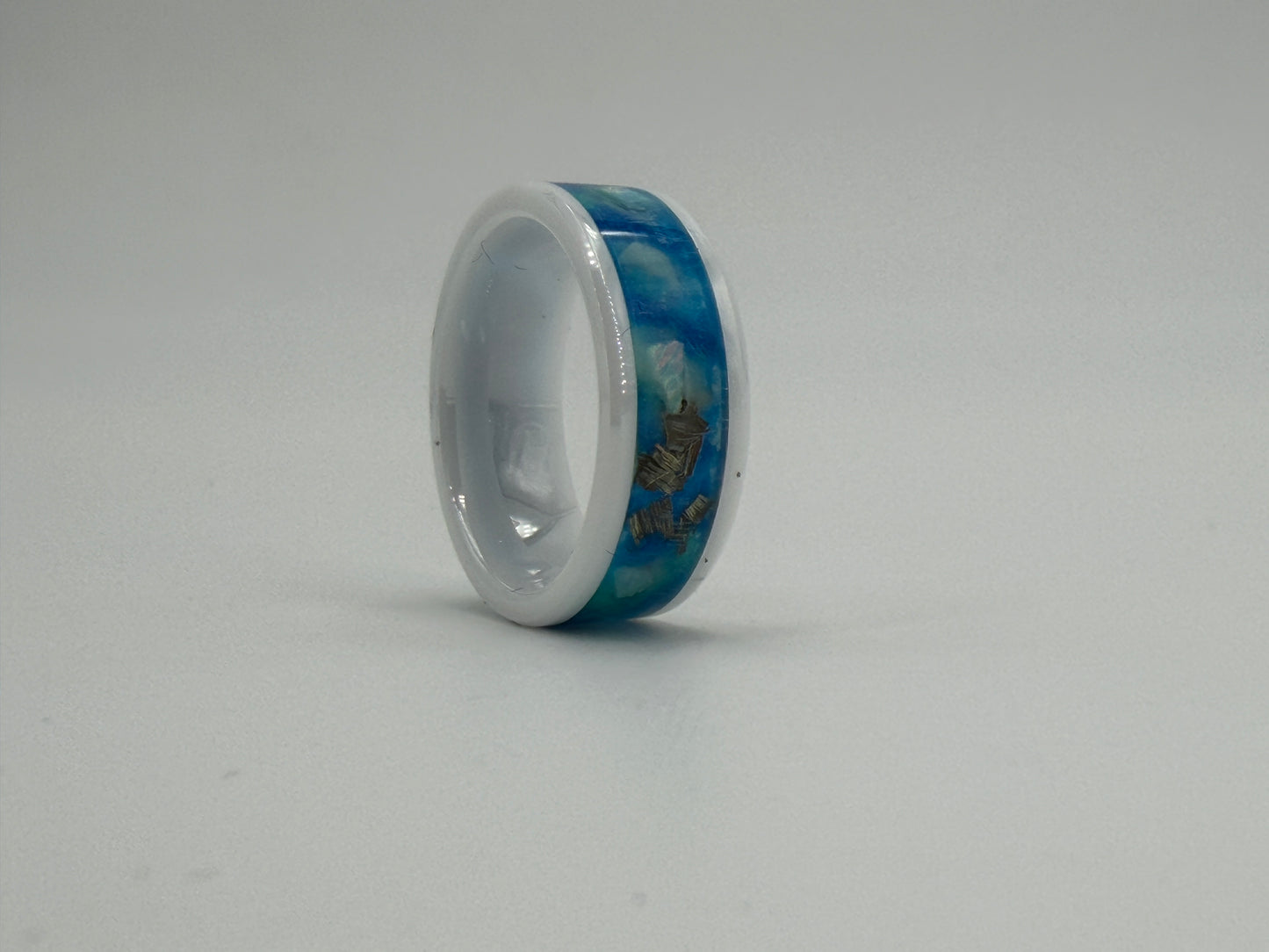 Ring aus Keramik mit blauen Opalen und Metallstückchen gefüllt.