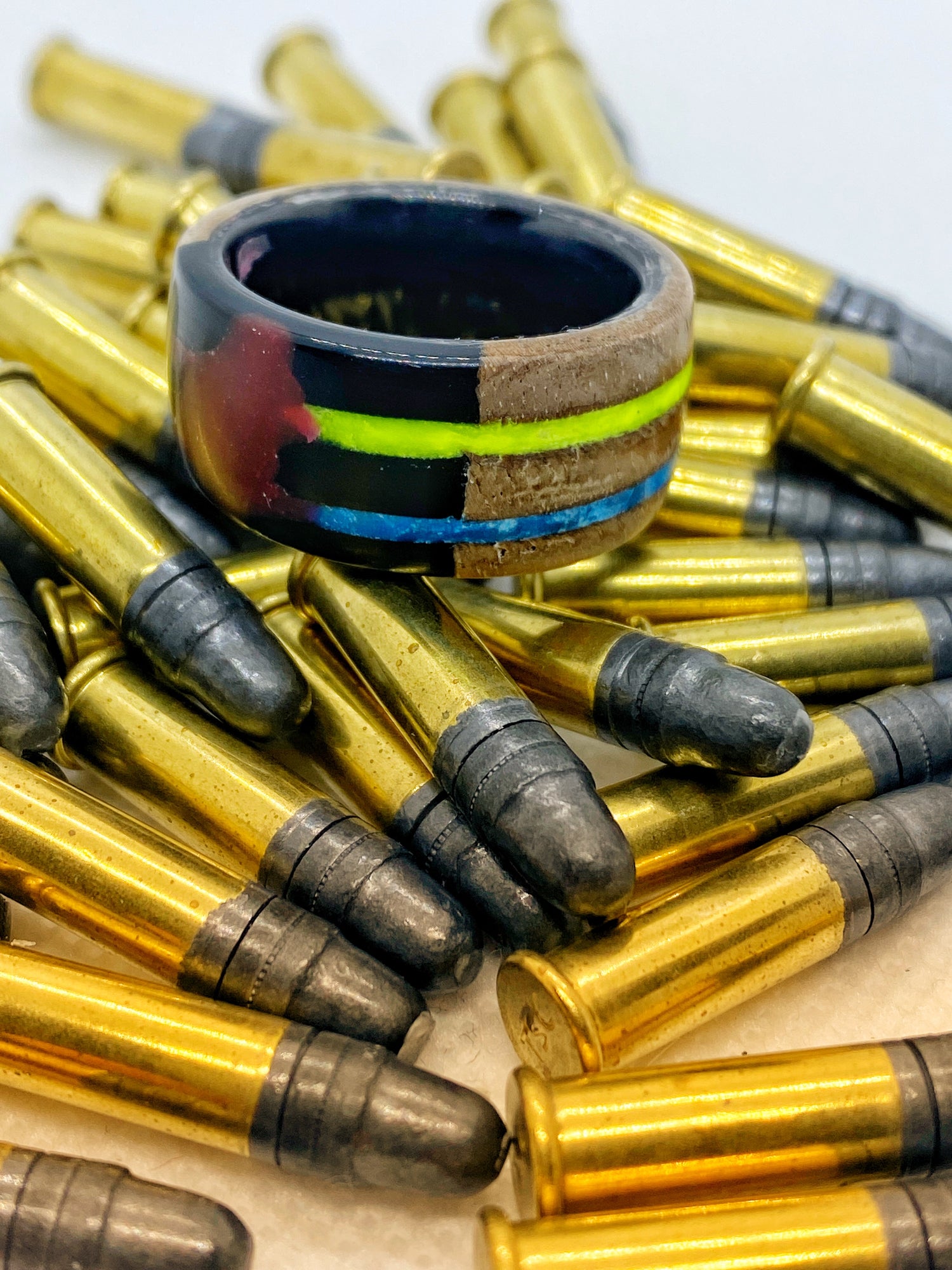 Ring Neighborly Disaster, gefertigt aus einem alten Gewehrkolben in den Farben der Ukraine. Die Rückseite zeigt Zerstörung und wurde mit rotem Harz (als Symbol für Blut) und schwarzem Harz (als Symbol für Öl) repariert – ein Werk zwischen Erinnerung, Gewalt und Widerstand.
Neighborly Disaster ring, crafted from an old rifle stock in the colors of Ukraine. The back bears traces of destruction, repaired with red resin (symbolizing blood) and black resin (symbolizing oil) – a piece balancing mem