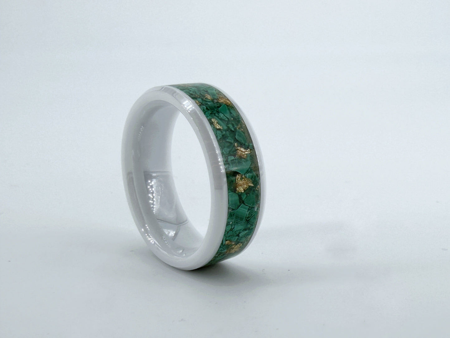 Viridis Aurea – handgefertigter Ring aus weißer Keramik mit grünem Stein aus Straßburg und Goldfolie, fotografiert vor weißem Hintergrund.