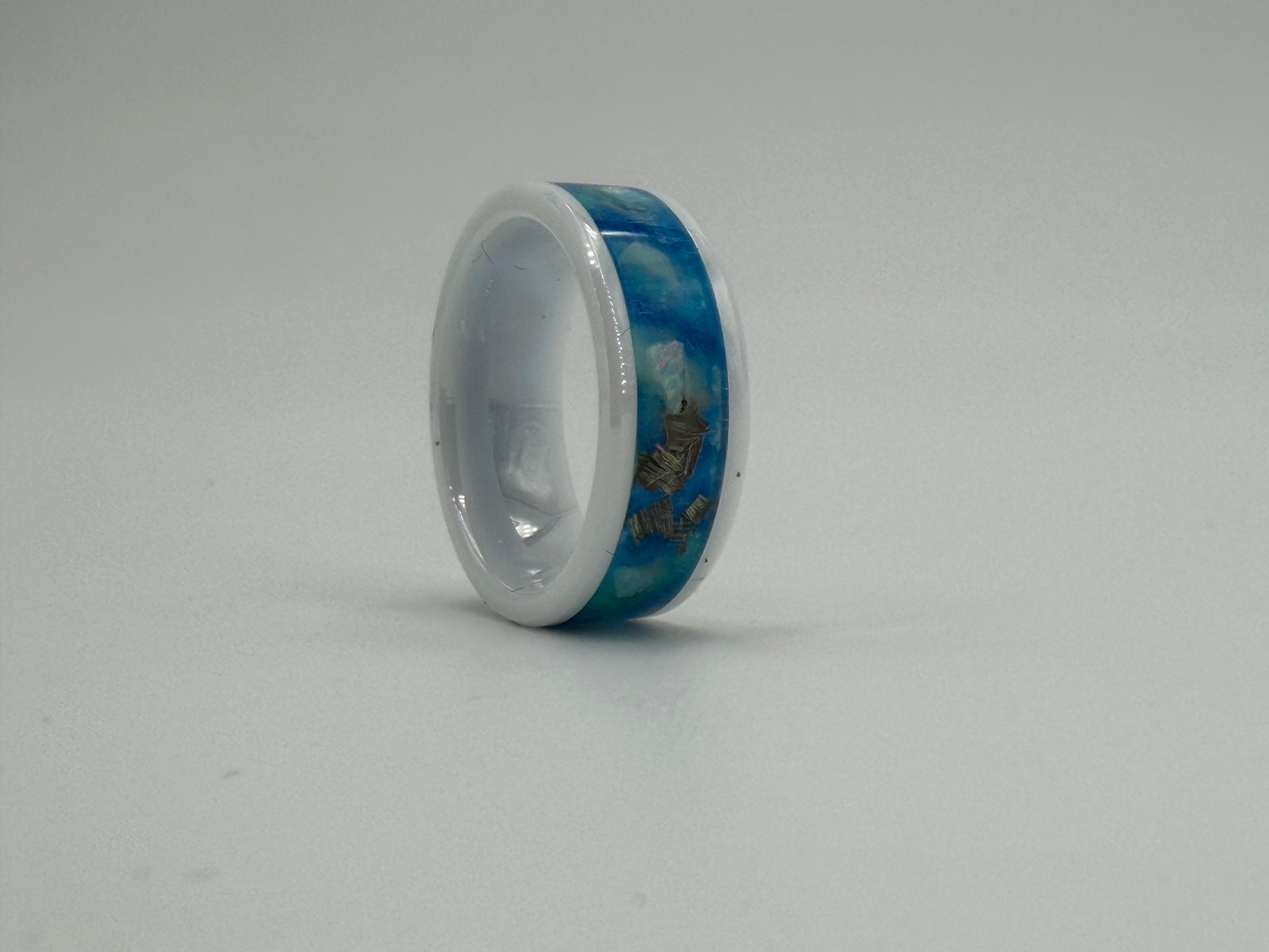 Ring aus Keramik mit blauen Opalen und Metallstückchen gefüllt.