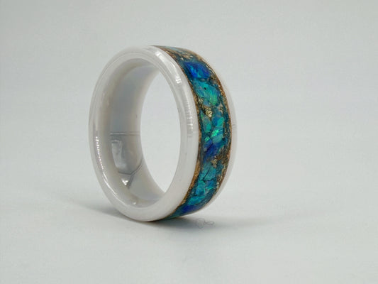 Handgefertigter Ring „Aether Aurum“ aus weißer Keramik mit leuchtend blauen Opalen und goldenen Akzenten. Die Kombination aus Weiß, Blau und Gold erinnert an Himmel, Licht und die Weite des Äthers und verleiht dem Unikat eine elegante, zeitlose Ausstrahlung.
