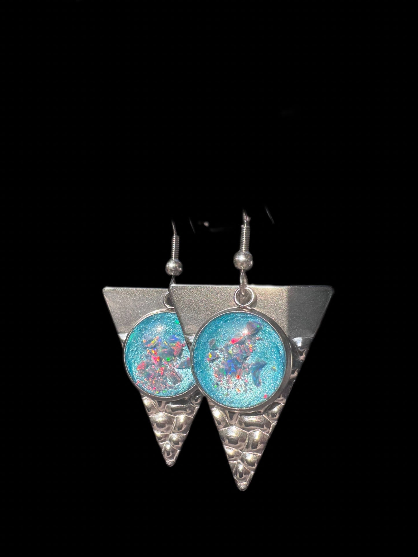 Handgefertigte Dangle-Ohrringe in Dreiecksform mit hellblauer Füllung. Die geometrische Form kombiniert mit der tiefen Farbe verleiht den Ohrringen eine moderne, elegante Ausstrahlung.

Handmade dangle earrings in triangular shape with light blue filling. The geometric form combined with the deep color gives the earrings a modern, elegant appearance.