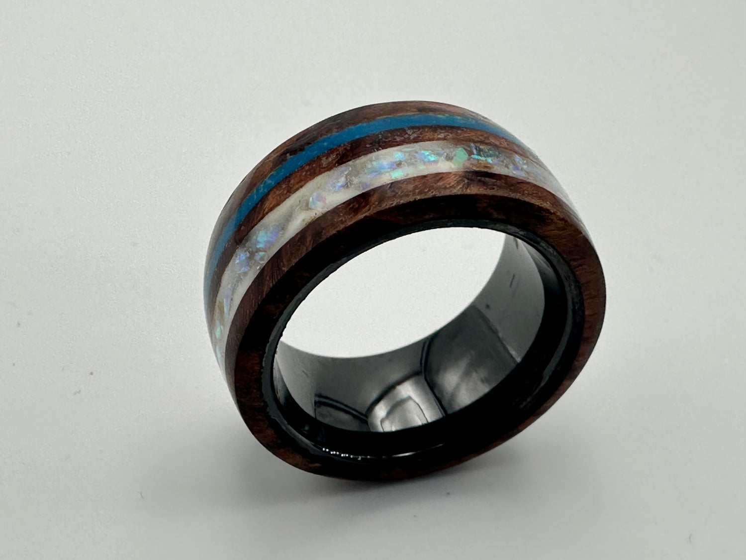Detail
🇩🇪 „Ring Winter – Detailaufnahme, Ebenholz mit blauer und weißer Opalstreifen“
🇫🇷 « Bague Winter – détail, ébène avec bandes d’opale bleue et blanche »
🇬🇧 “Ring Winter – detail shot, ebony with blue and white opal stripes”