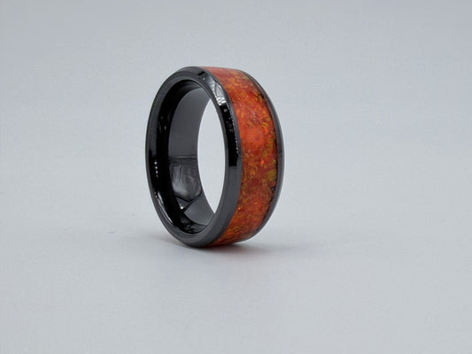 Ring aus schwarzer Keramik, gefüllt mit orangenen Opalen, handgefertigt im Atelier Artinrings.