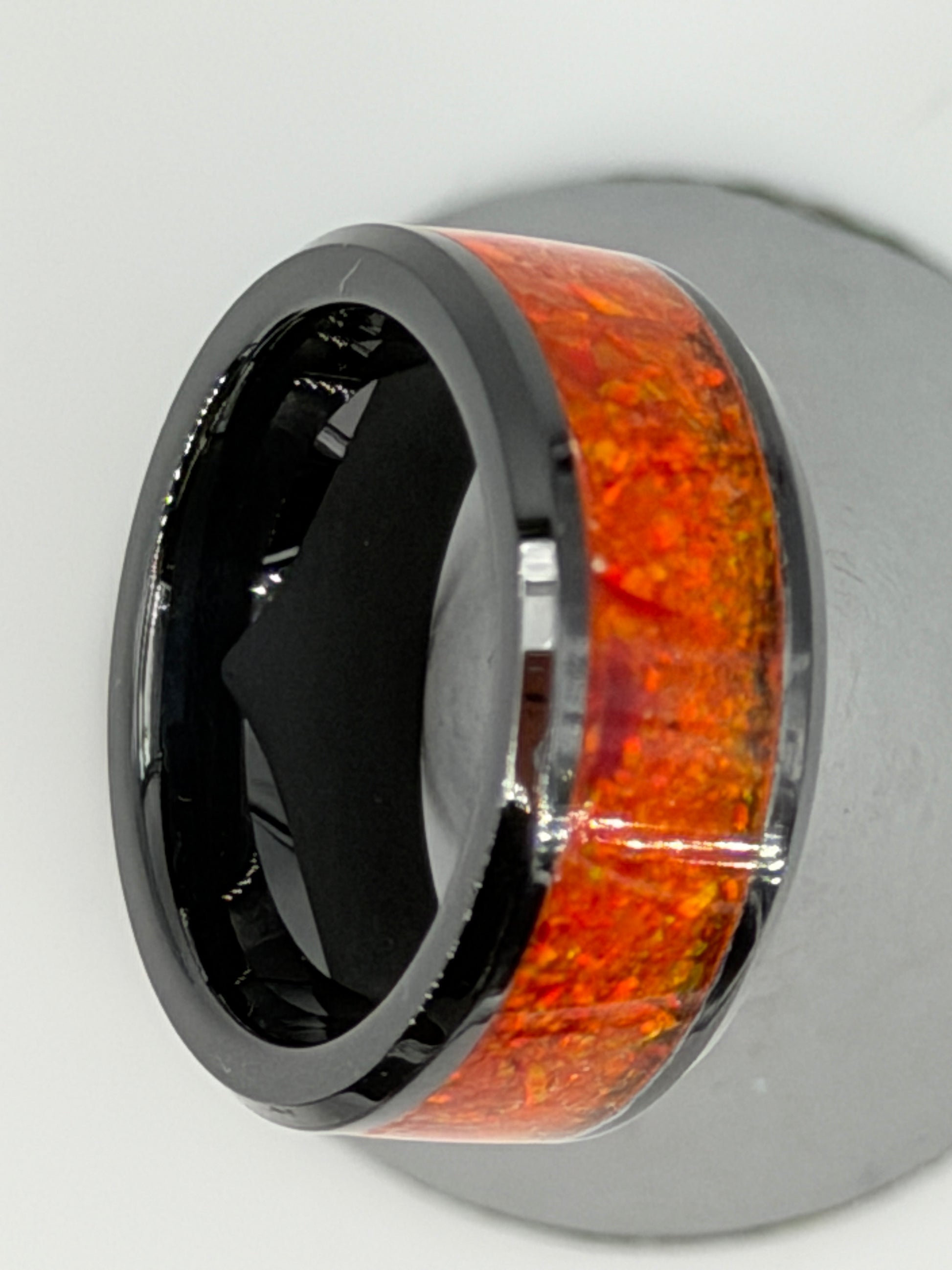 Ring aus schwarzer Keramik, gefüllt mit orangenen Opalen, handgefertigt im Atelier Artinrings.