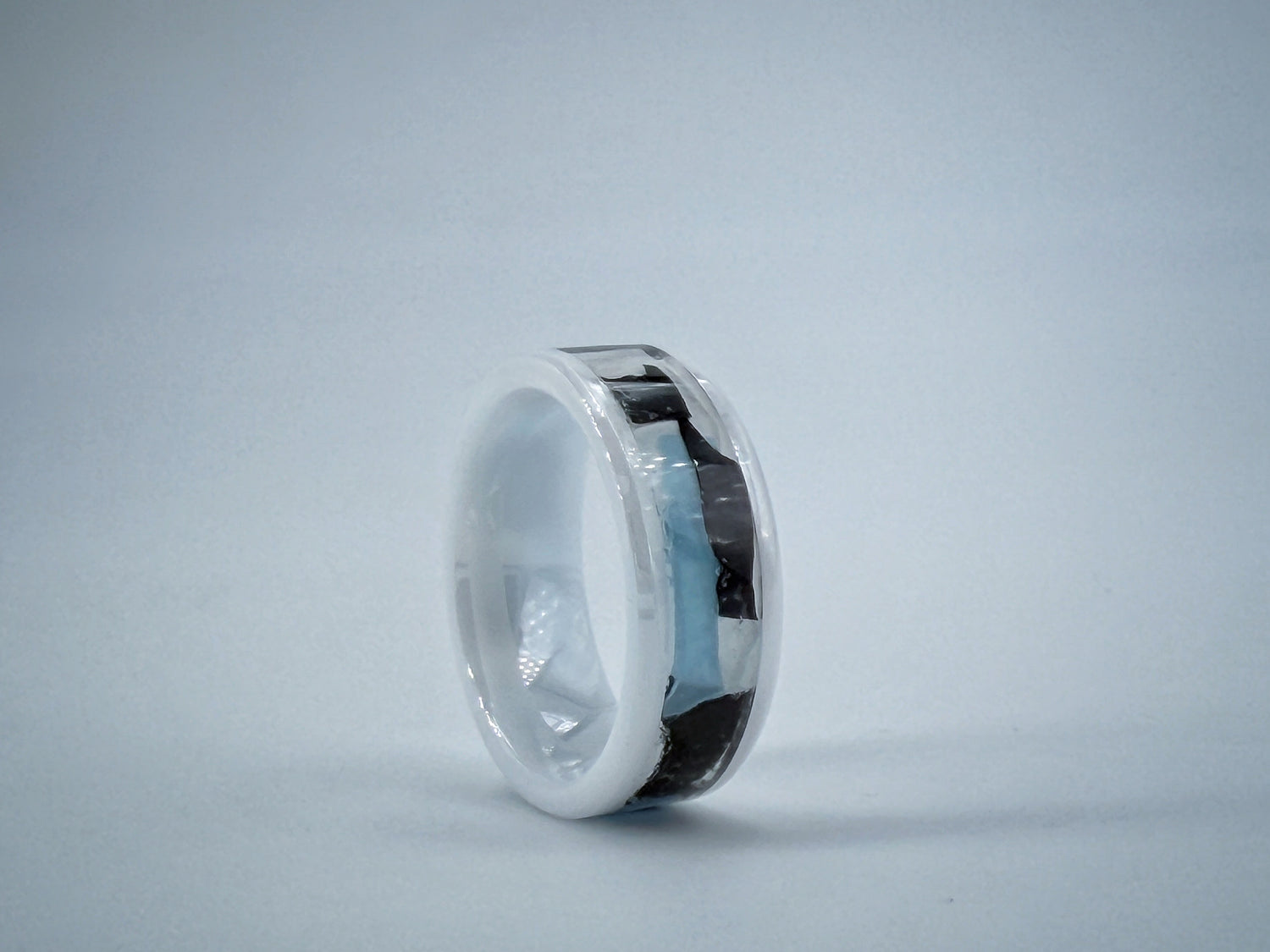 White marble-like ring sculpture symbolizing Illness, with a polished ceramnic core and smooth minimalist surface containing medical gloves.