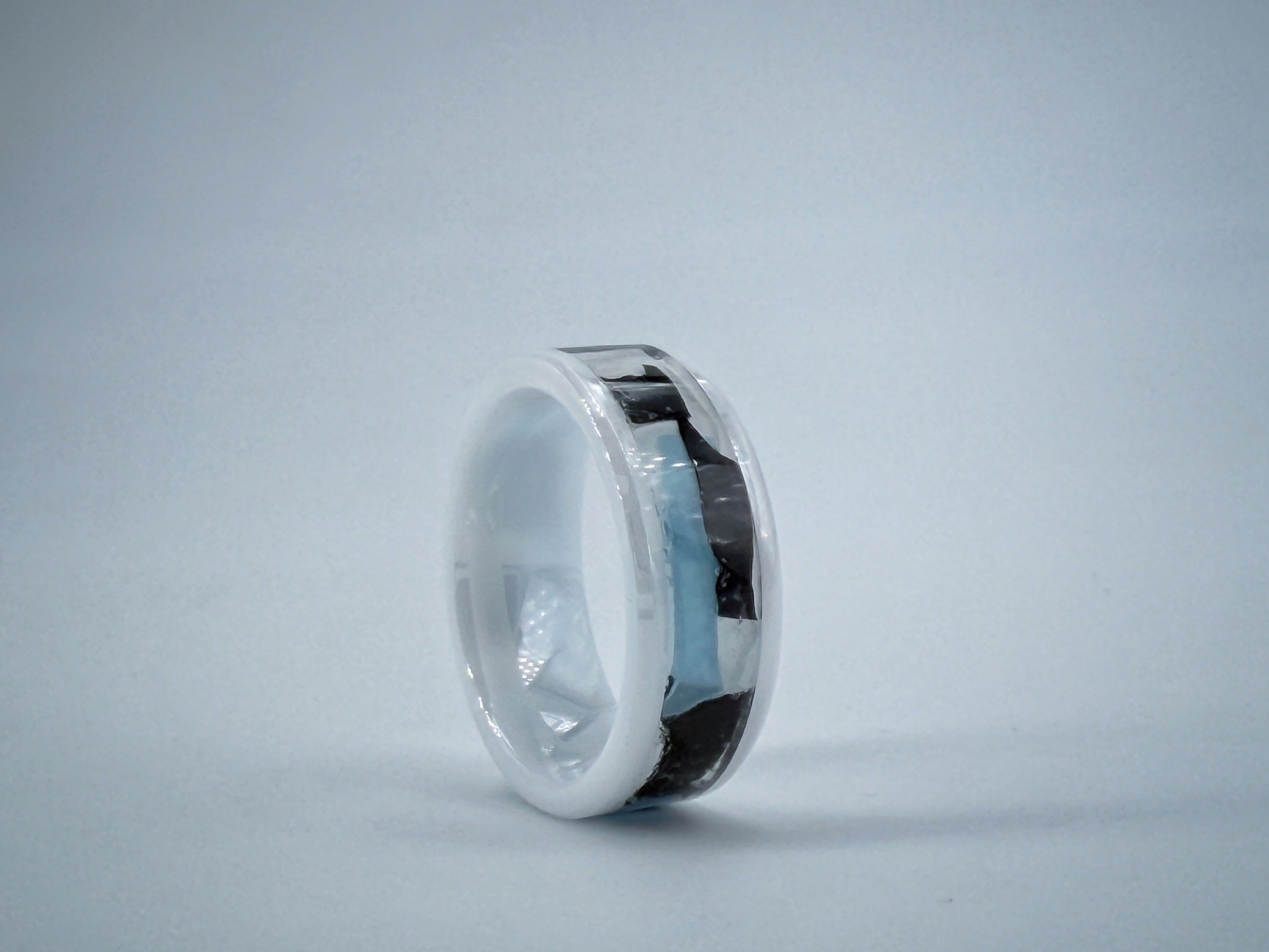 White marble-like ring sculpture symbolizing Illness, with a polished ceramnic core and smooth minimalist surface containing medical gloves.