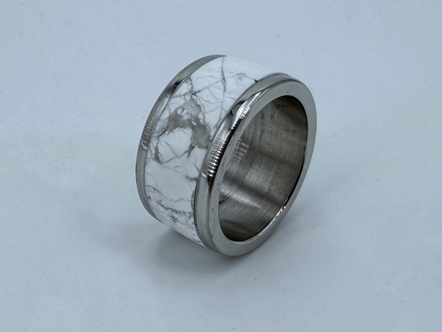 White marble-inspired ring sculpture with polished steel core, symbolizing shelter and spiritual refuge in the “Non Nobis” series.