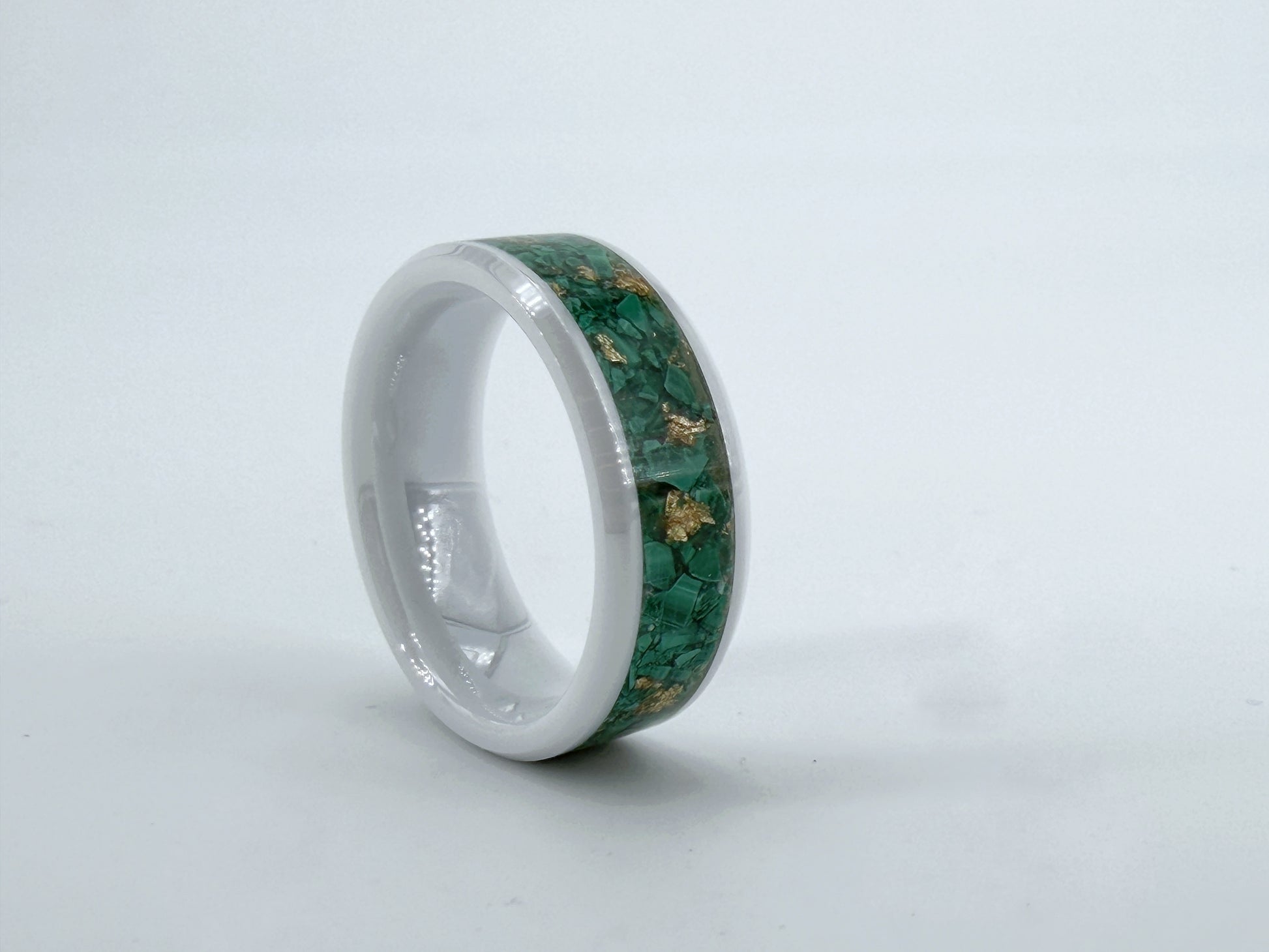 Viridis Aurea – handgefertigter Ring aus weißer Keramik mit grünem Stein aus Straßburg und Goldfolie, fotografiert vor weißem Hintergrund.
