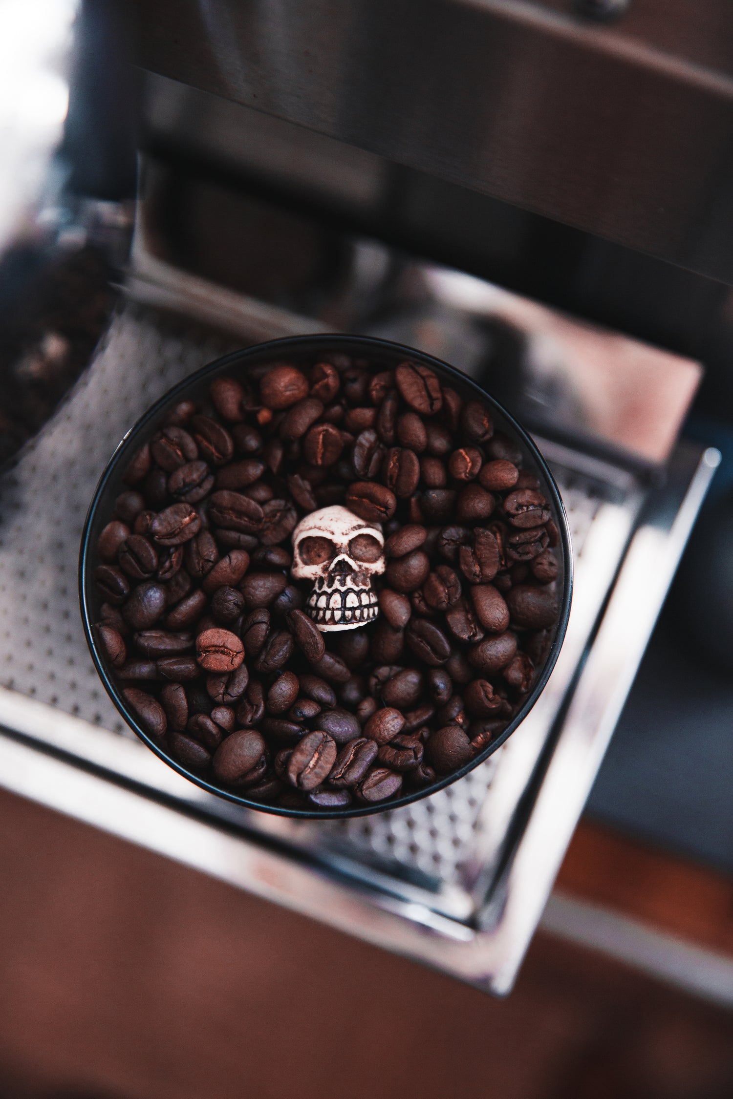 Platzhalterbild: Tasse mit Kaffebohnen und Schädelperle darin
